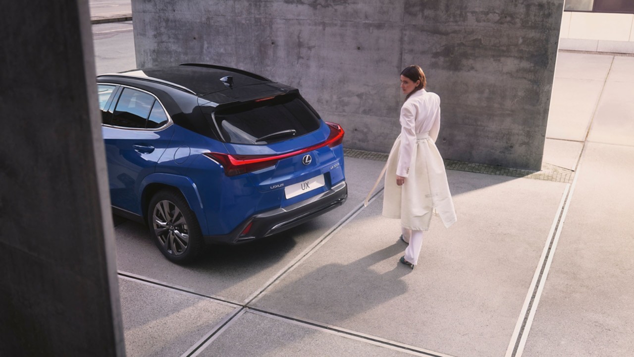 A person stood next to a parked Lexus UX