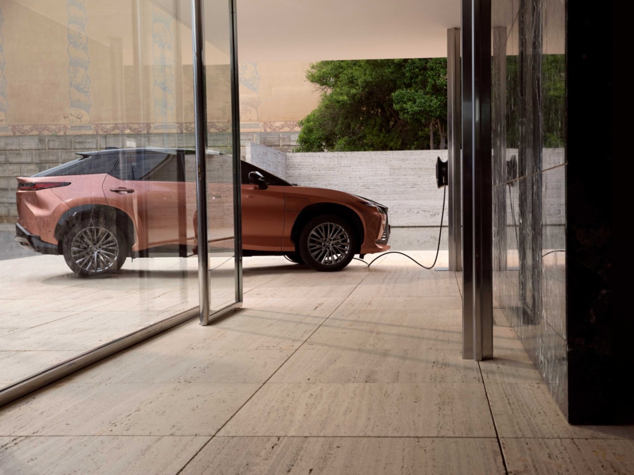 A person plugging in a charging socket into a Lexus